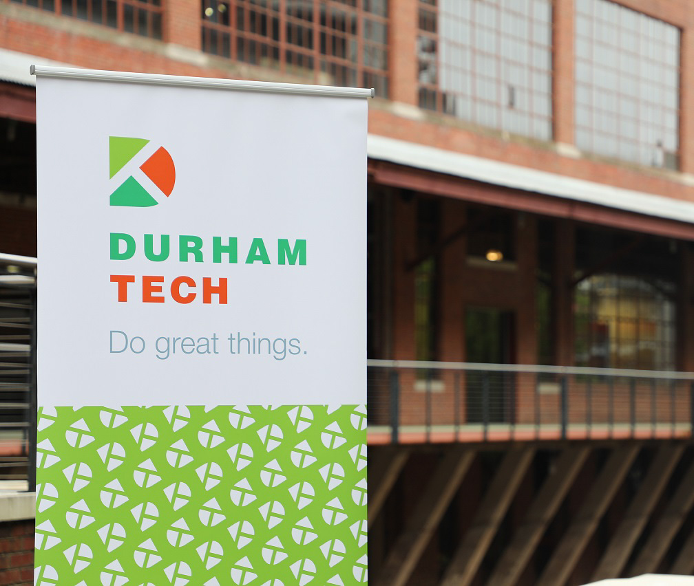 durham tech logo sign in front of brick building in background