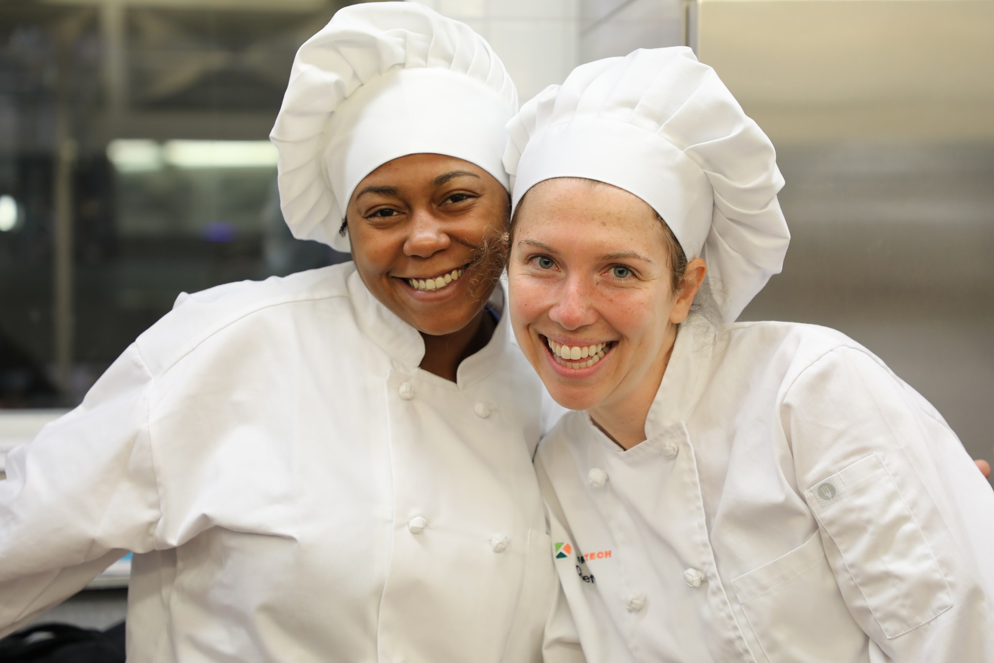 two smiling culinary arts students 