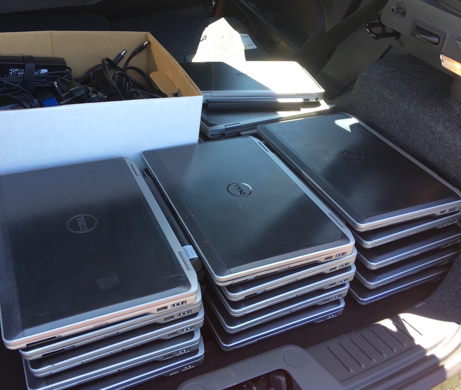 pile of laptops in back of vehicle