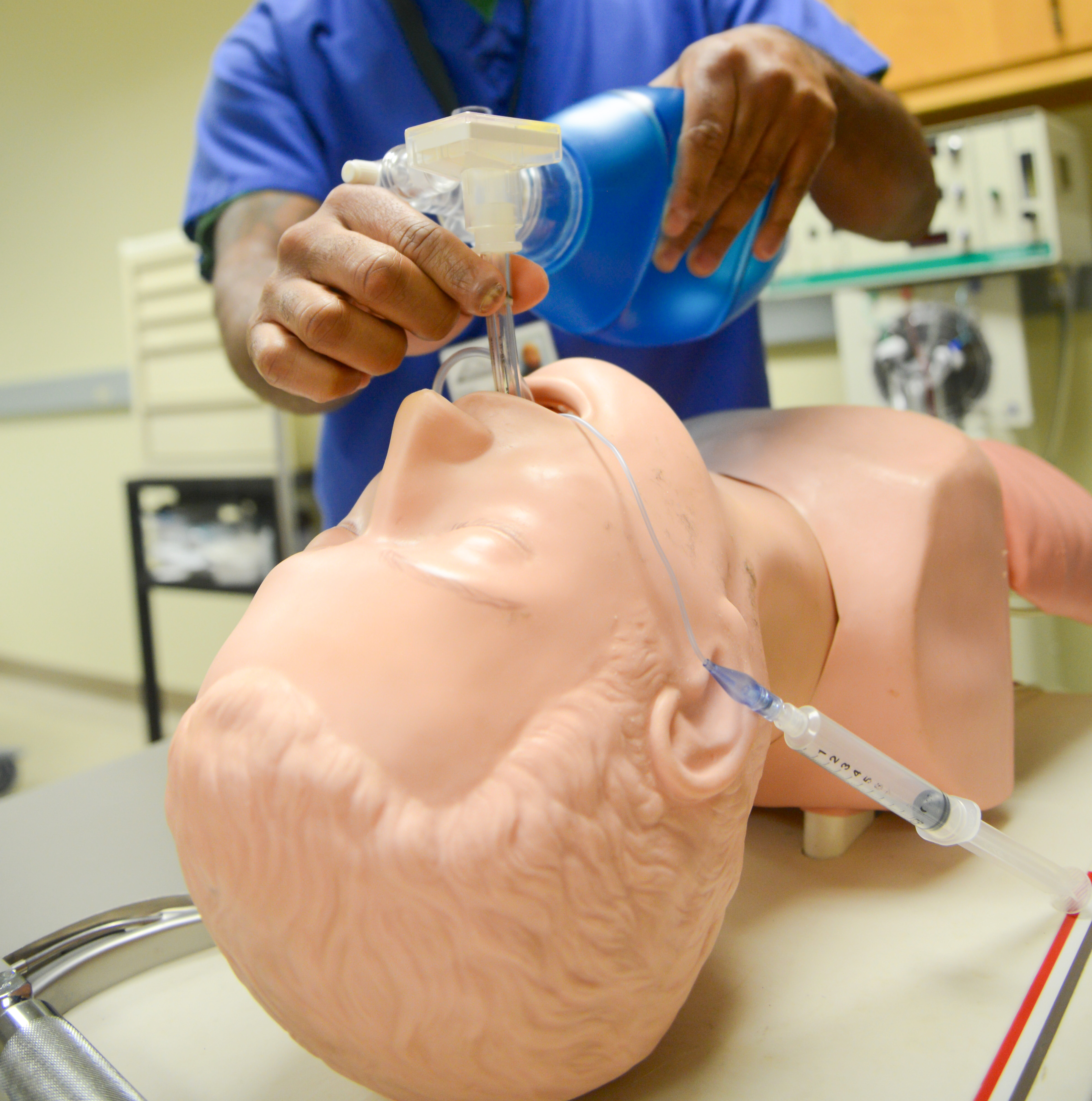 student standing over a mannequin and practicing intubation