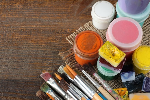 paint buckets and brushes on piece of wood