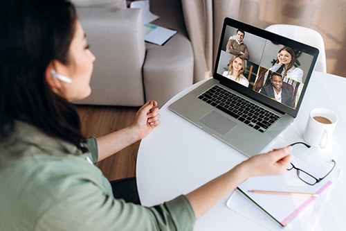 student in business attire meets via computer with company recruiters