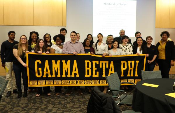group photo of students holding sign that says gamma beta phi