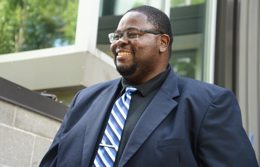 photo of decarlos hickson wearing a blue suit and smiling