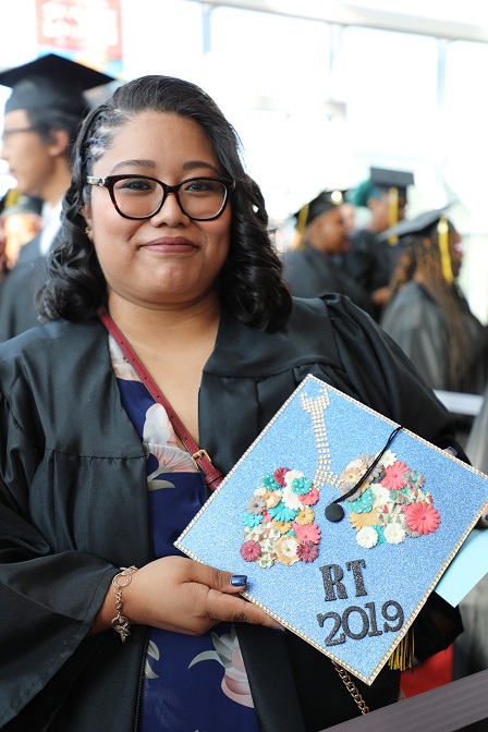 dulce holding cap at graduation ceremony and smiling