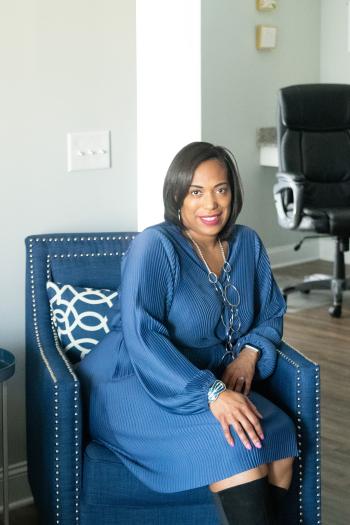 Precious Vines-Harris sitting at home in a blue armchair