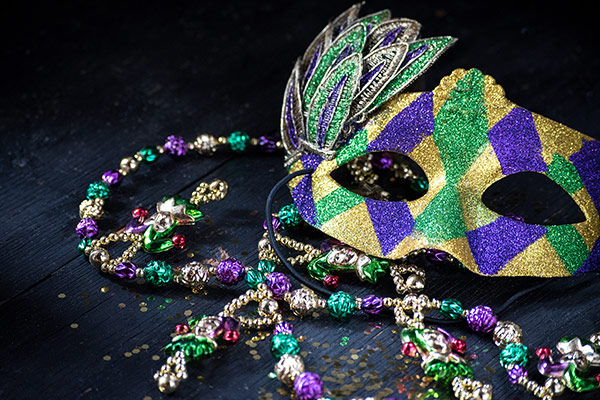 colorful mask with feathers amid bead necklace