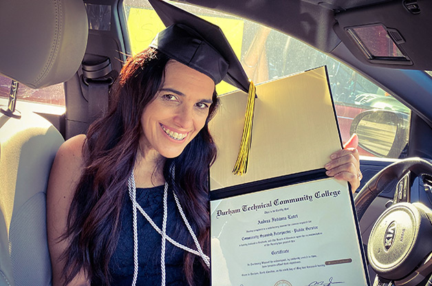 graduate in mortarboard holding her diploma