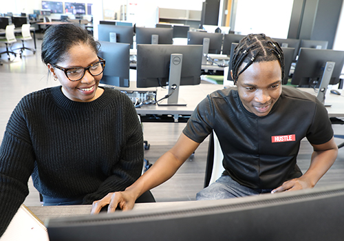 IT & Cloud Systems students looking at a computer screen in class