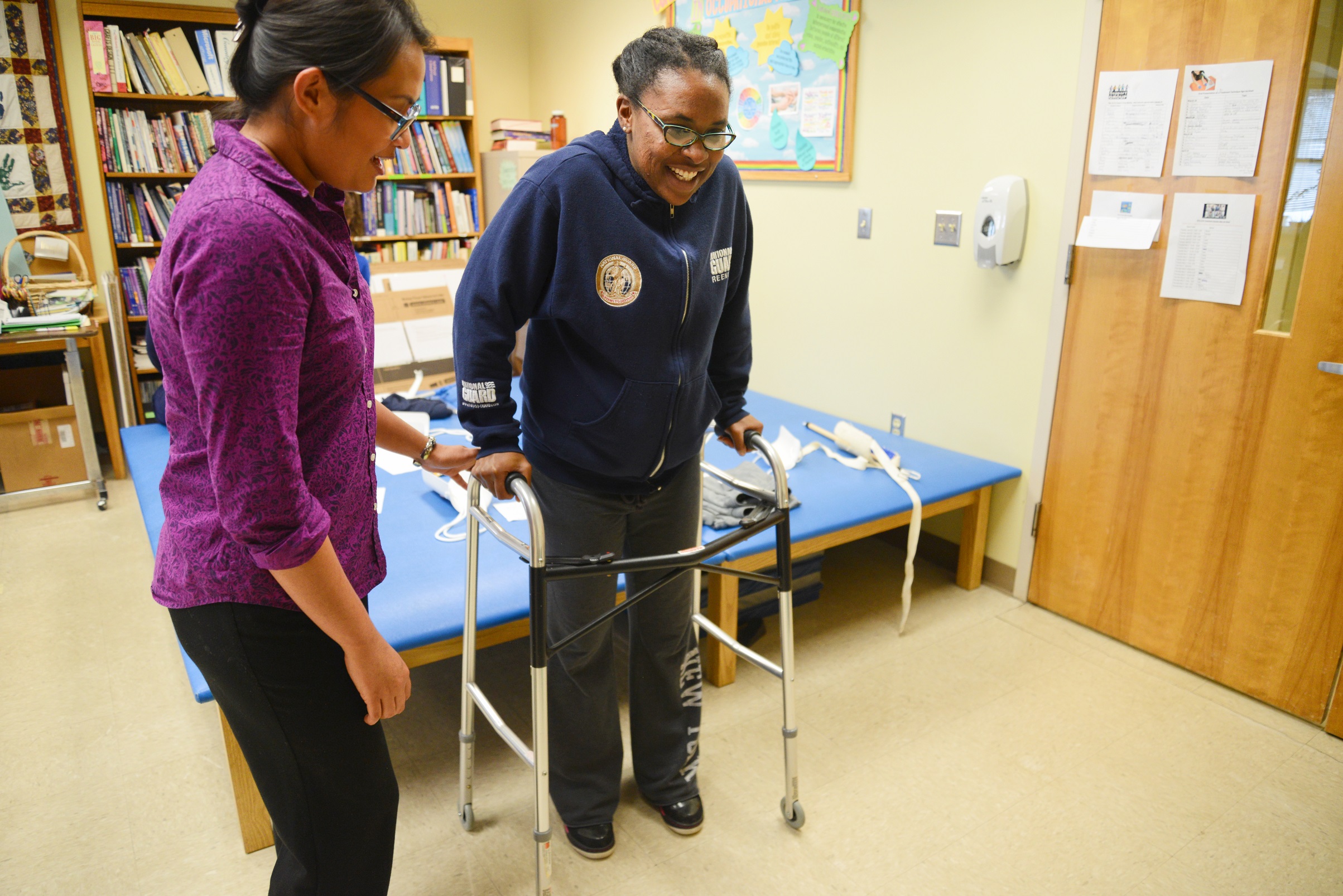 one student using a walker and another student assisting