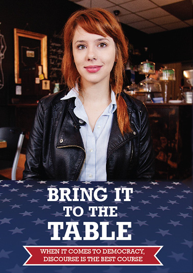 photo of woman with red hair sitting at table staring at camera